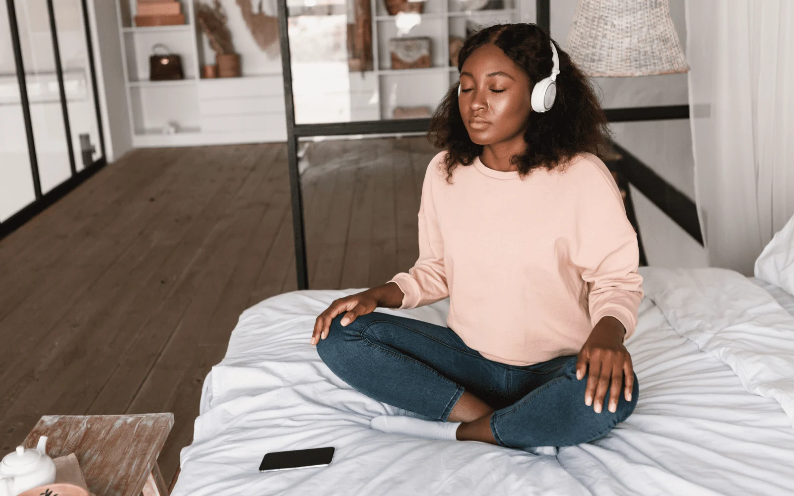 Femme assise, les yeux fermés, portant un casque audio