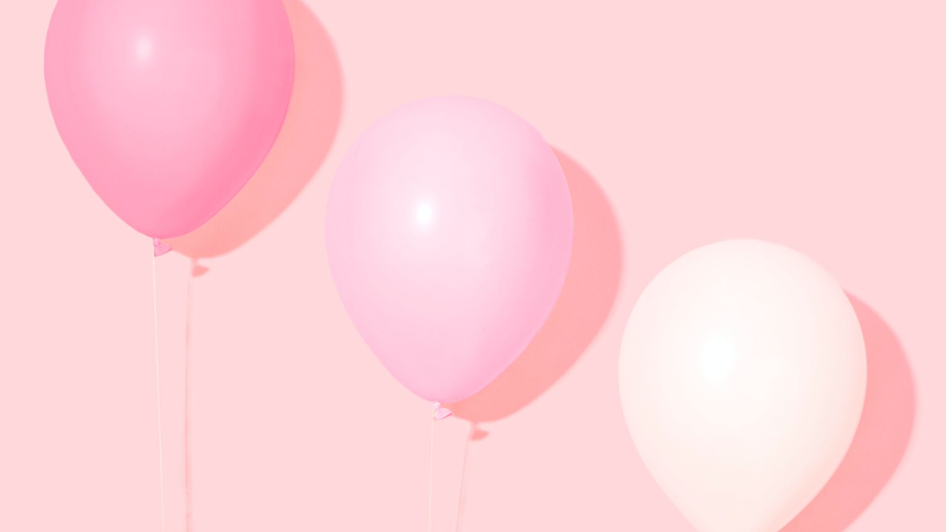 Ballons roses et blancs sur un fond rose