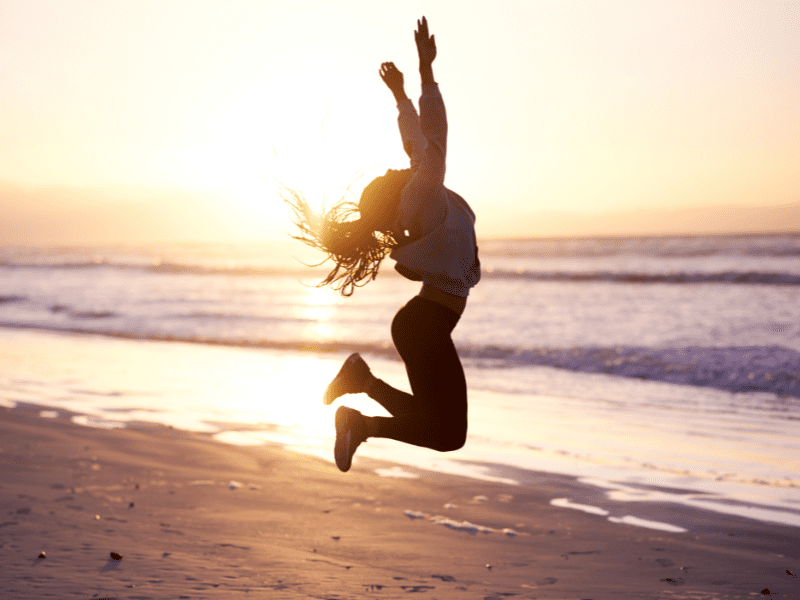 Femme sautant sur une plage