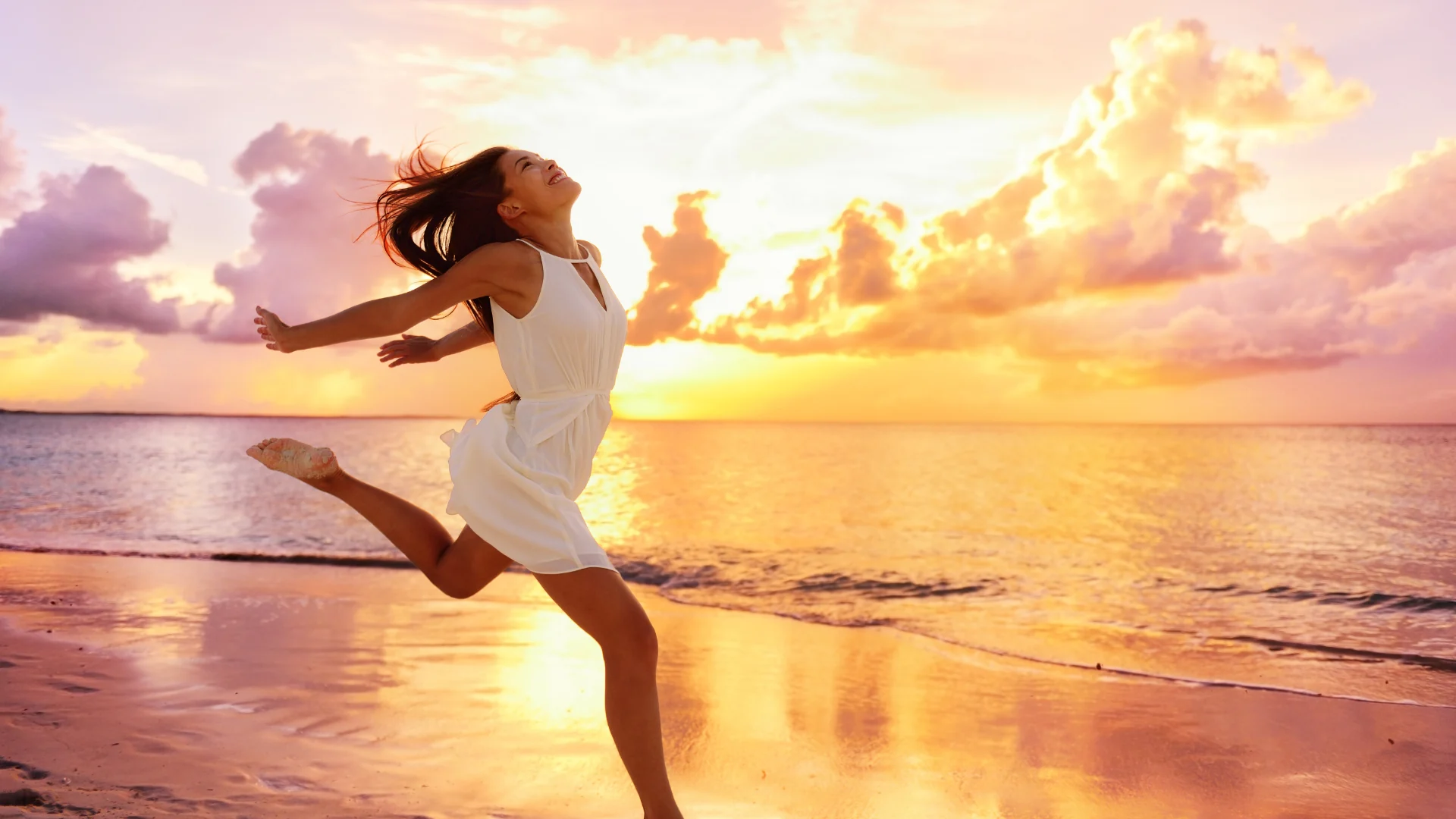Femme en mouvement sur une plage au coucher du soleil