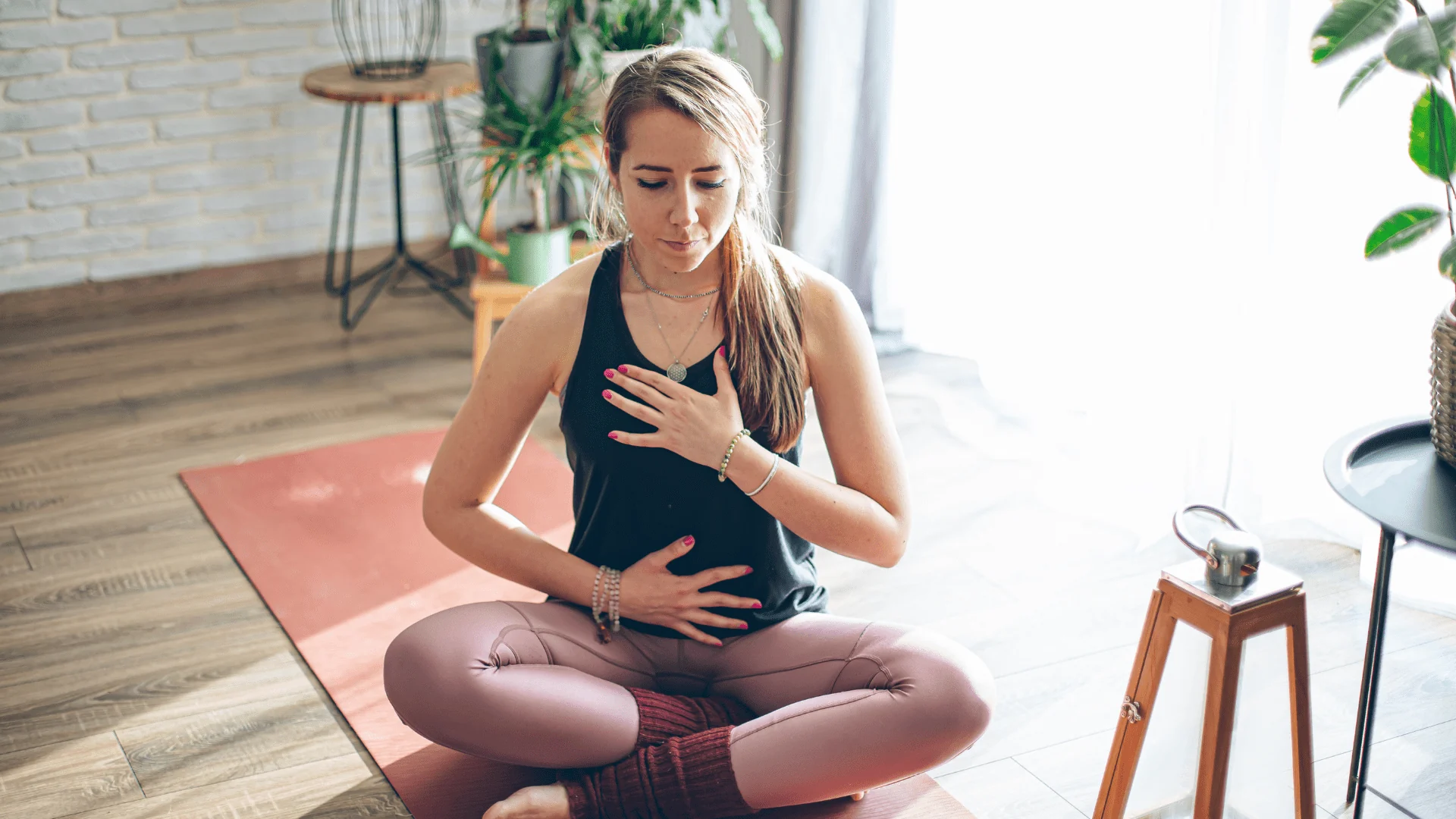 Femme assise avec une main sur la poitrine et l’autre sur le ventre
