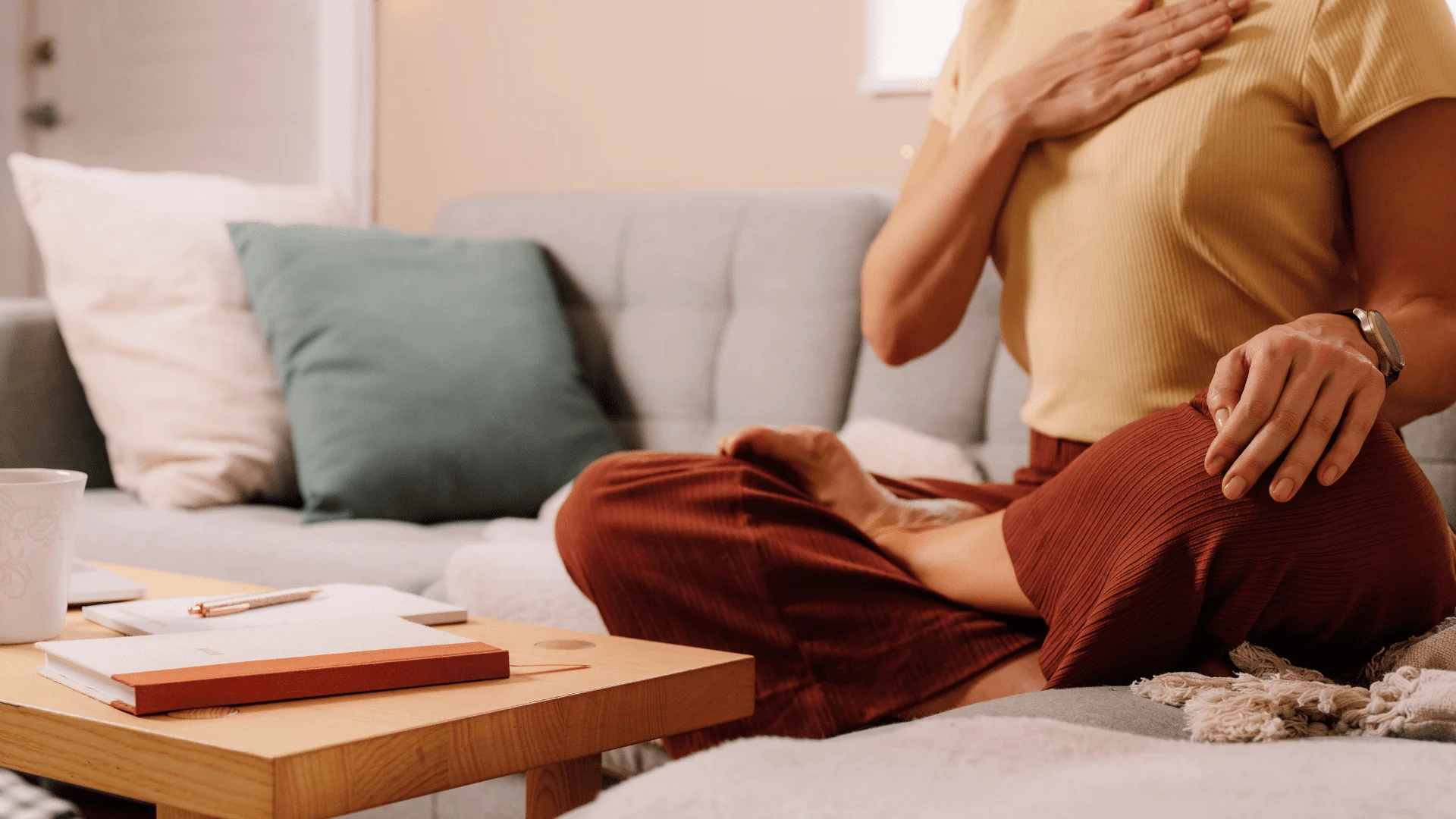 Personne assise, une main sur la poitrine