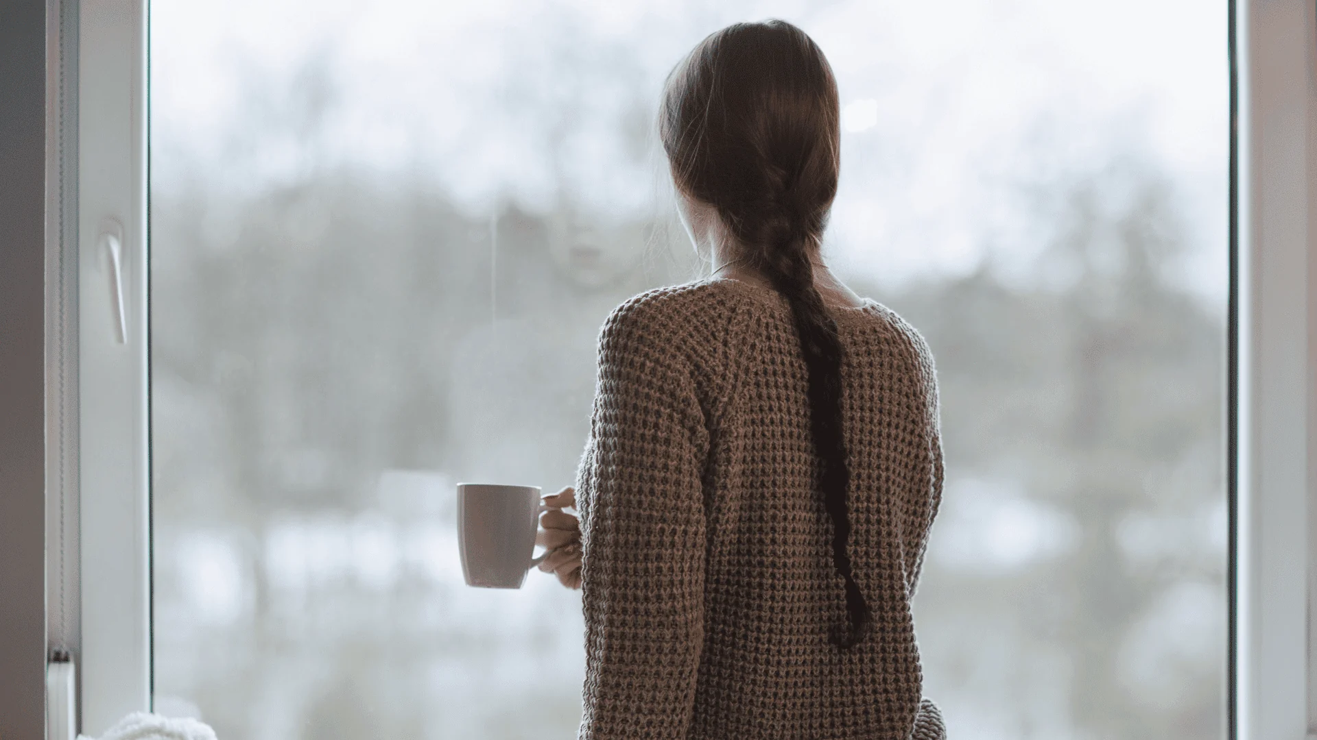 Femme debout devant une fenêtre