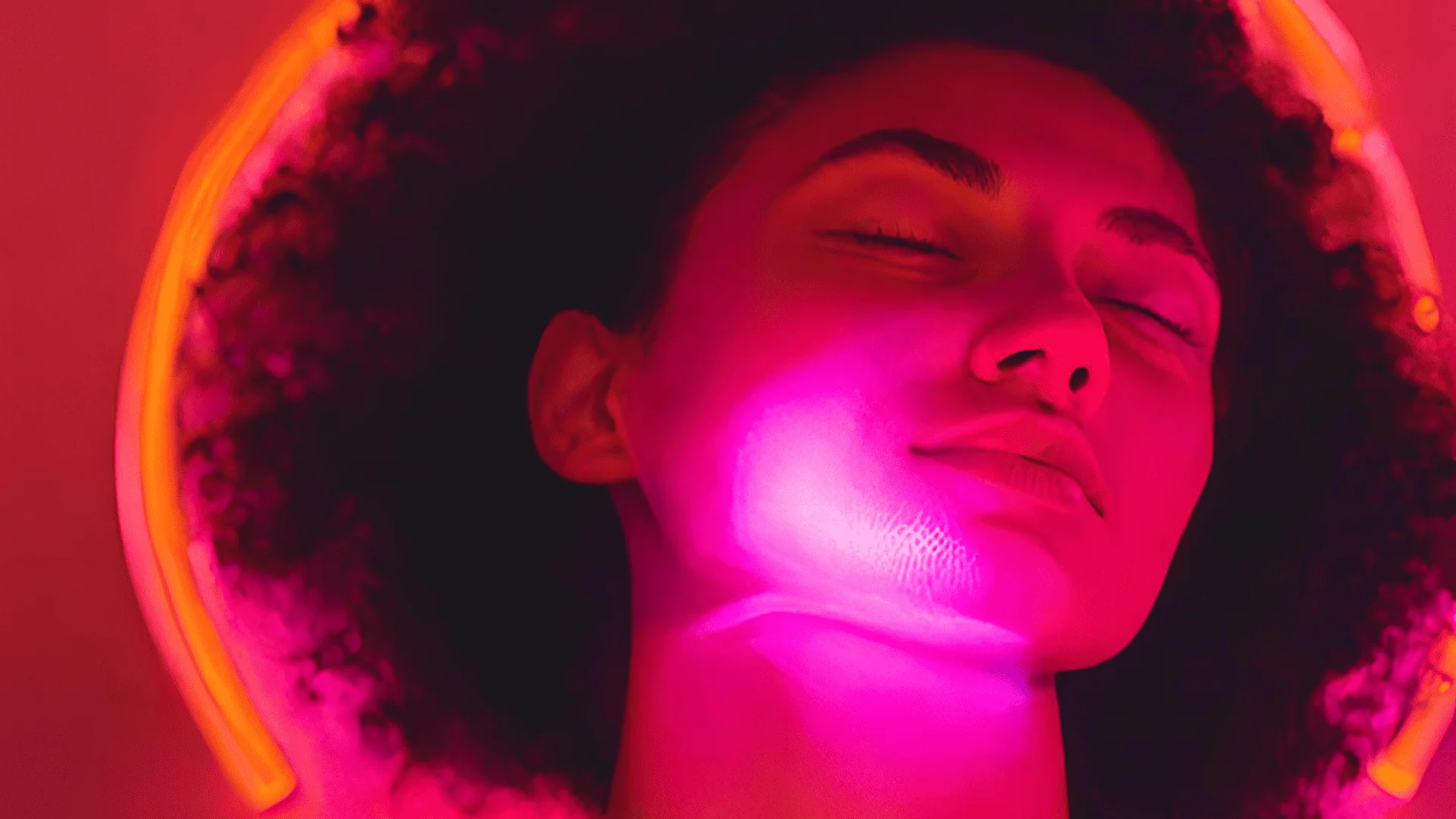 Femme avec un casque dans une lumière rose